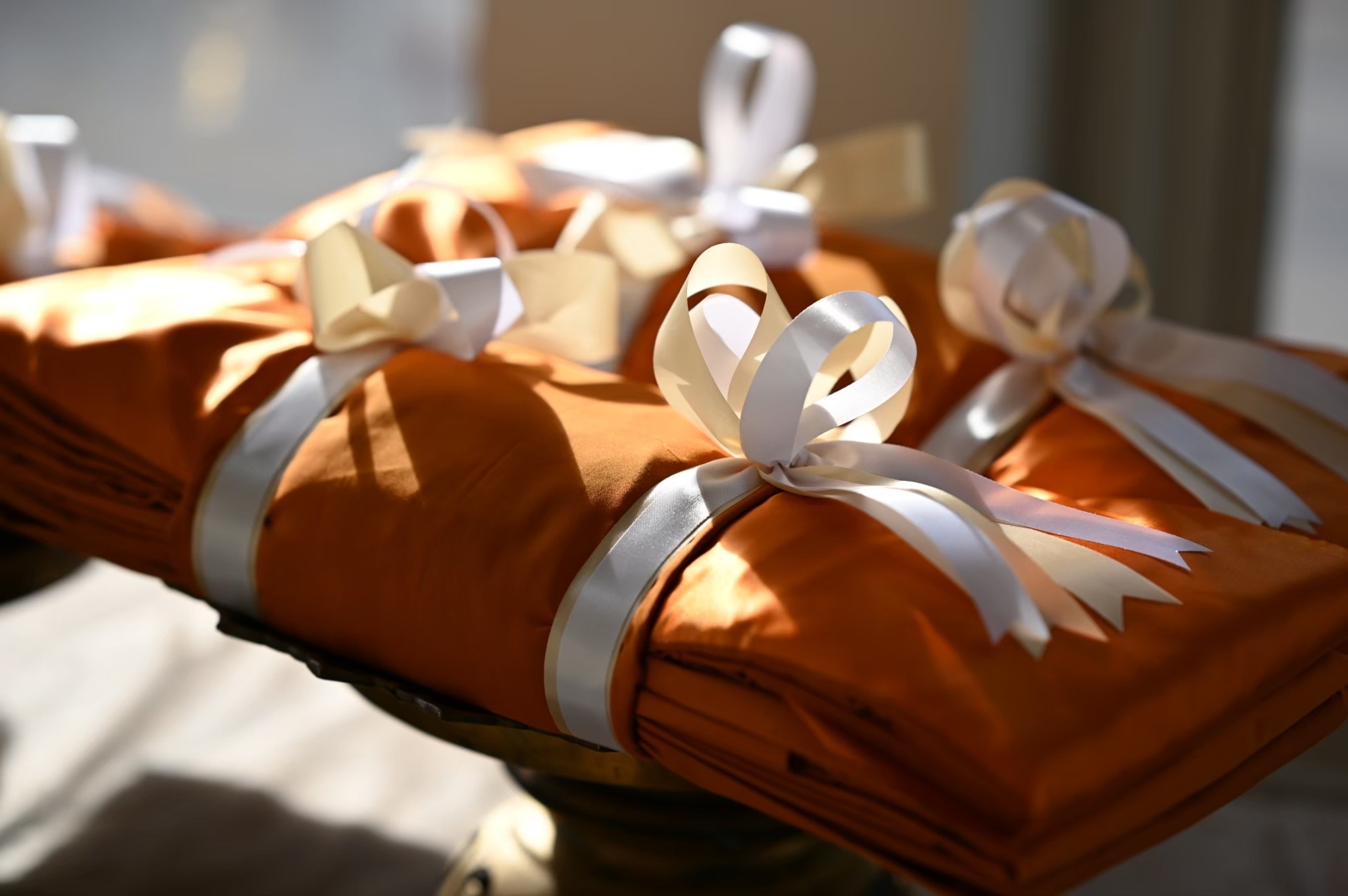Saffron monks robes folded with white satin ribbons