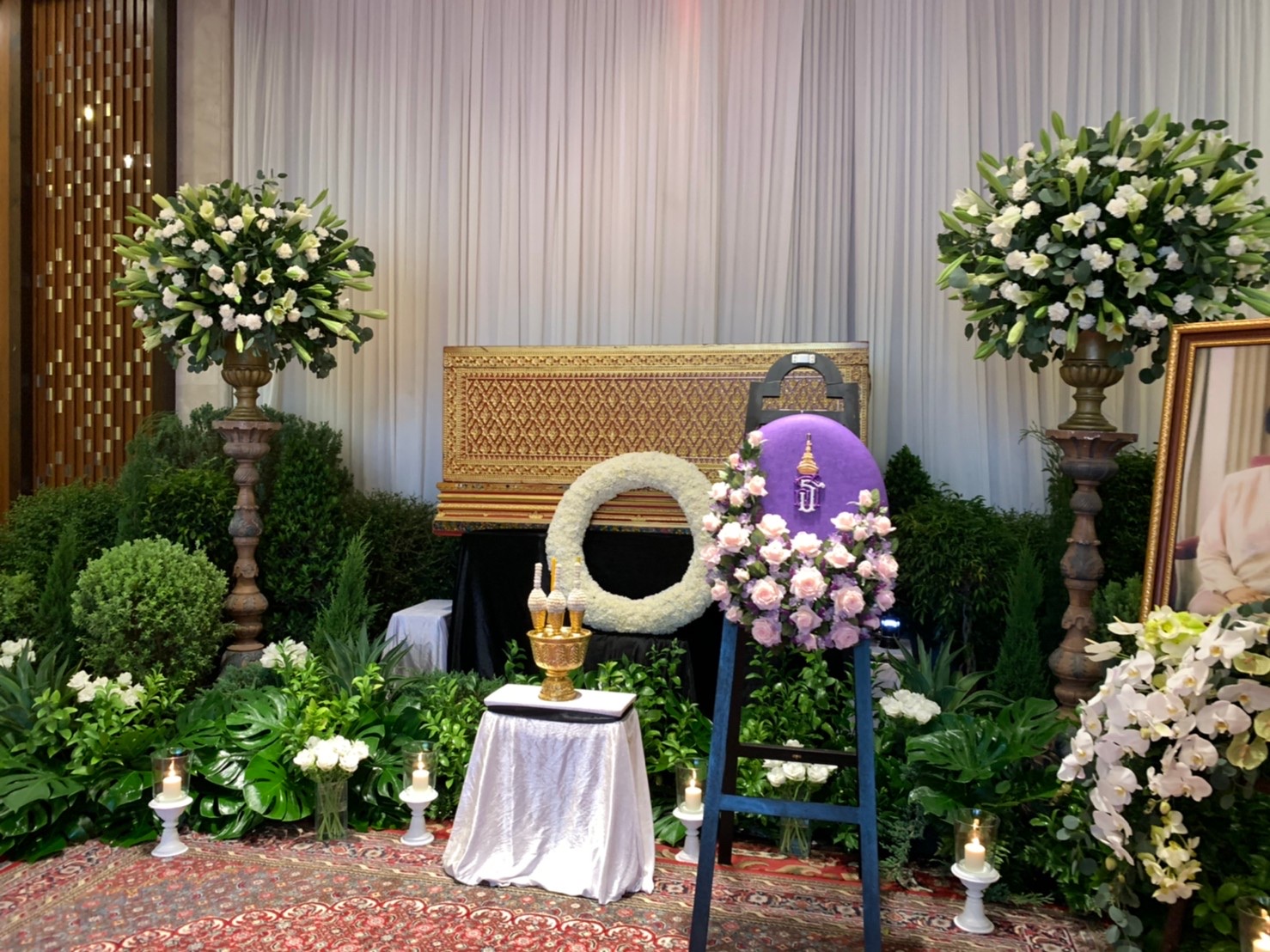 Ceremony hall with royal purple cremation wreath and lily arrangements